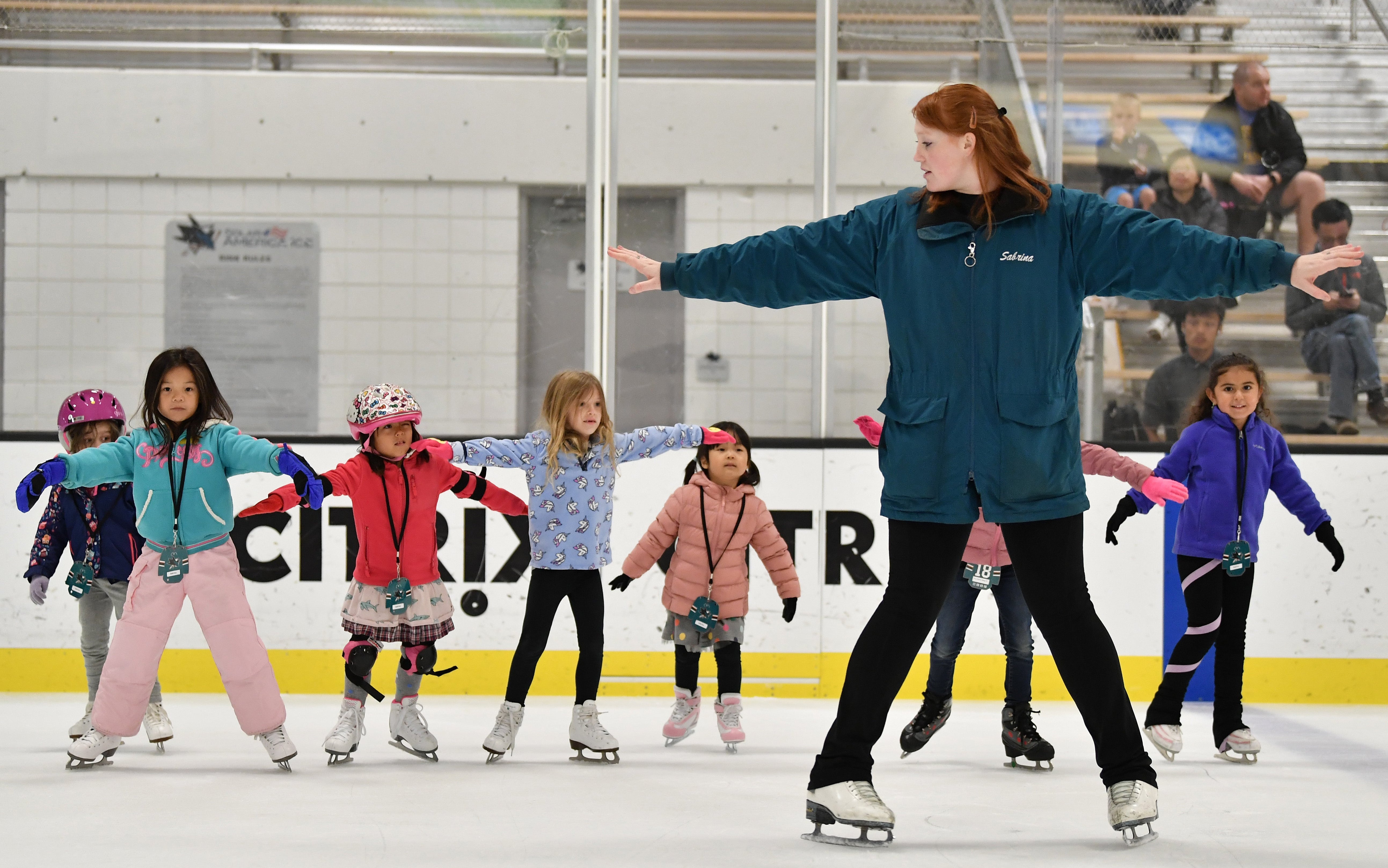 Kids ice skating with coaching